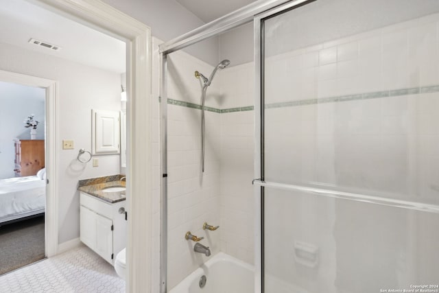 bathroom featuring tiled shower / bath, vanity, and tile patterned flooring