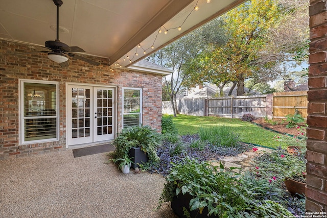 view of yard featuring ceiling fan and french doors