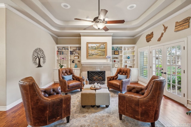 sitting room featuring hardwood / wood-style flooring, a premium fireplace, and a tray ceiling