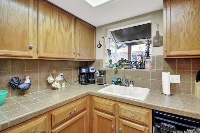 kitchen featuring dishwasher, backsplash, and sink