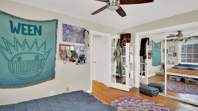 bedroom with ceiling fan, wood-type flooring, and a closet