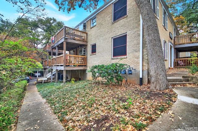 rear view of property with a wooden deck and a balcony