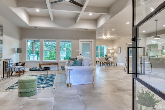 living room featuring ceiling fan, beam ceiling, and coffered ceiling