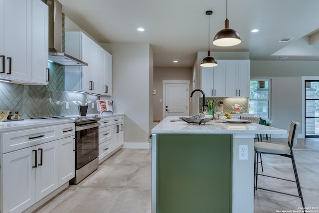 kitchen featuring a center island with sink, decorative light fixtures, white cabinetry, and electric range