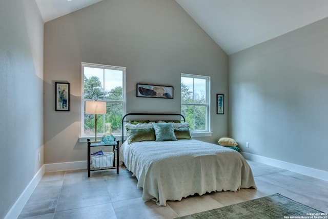 bedroom featuring multiple windows and high vaulted ceiling