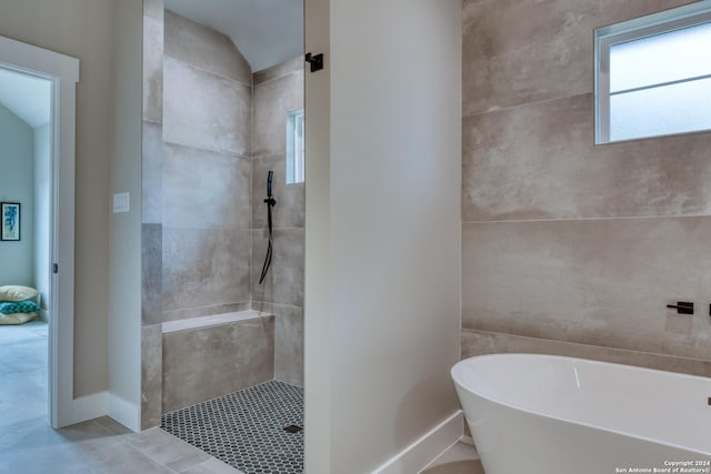 bathroom with separate shower and tub, tile patterned flooring, and lofted ceiling