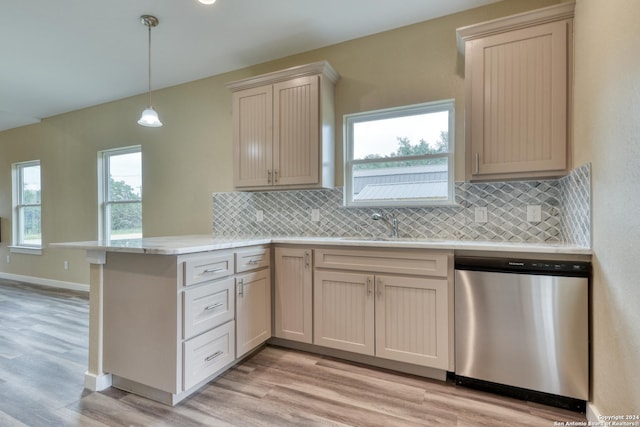 kitchen with stainless steel dishwasher, plenty of natural light, light wood-type flooring, and kitchen peninsula