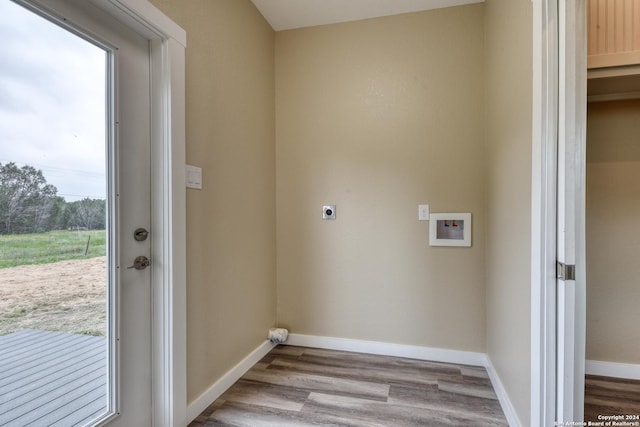 clothes washing area with hookup for an electric dryer, a healthy amount of sunlight, light wood-type flooring, and hookup for a washing machine