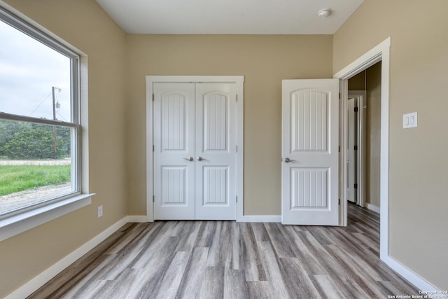 unfurnished bedroom with light hardwood / wood-style floors and a closet