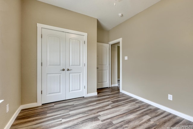 unfurnished bedroom with a closet and light hardwood / wood-style floors