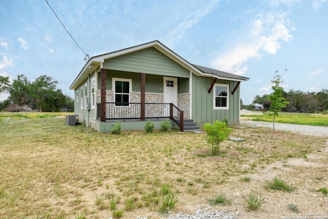 bungalow-style house with central AC unit, a porch, and a front lawn