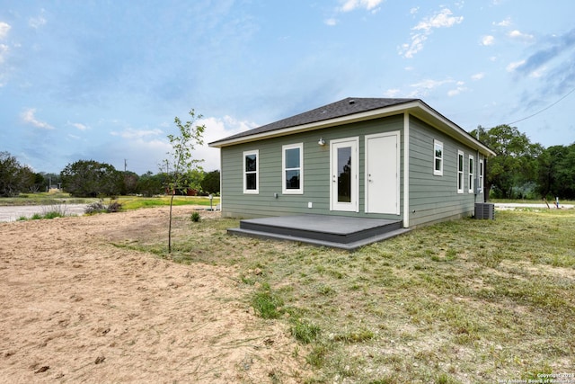 rear view of house with a lawn and central air condition unit