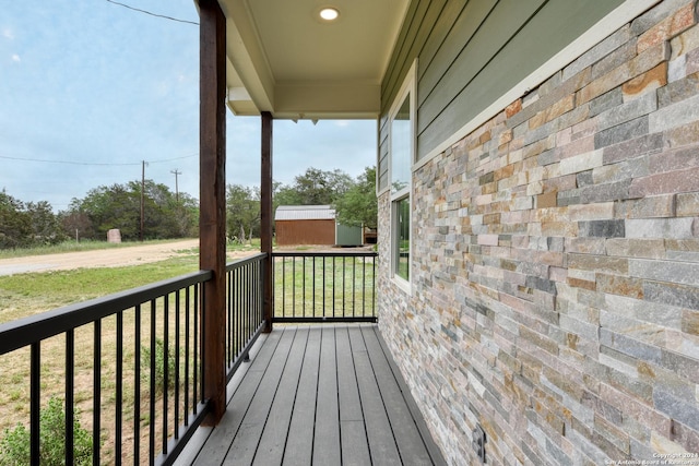 wooden deck featuring a storage unit and a yard