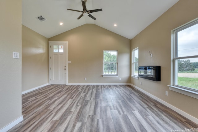 unfurnished living room with ceiling fan, light hardwood / wood-style floors, lofted ceiling, and a wealth of natural light