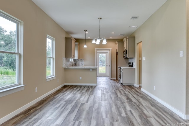 kitchen featuring decorative backsplash, a healthy amount of sunlight, stainless steel appliances, and decorative light fixtures