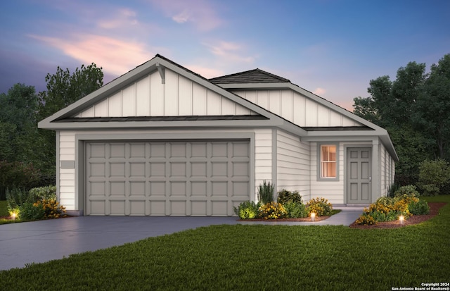 view of front of property with a yard and a garage