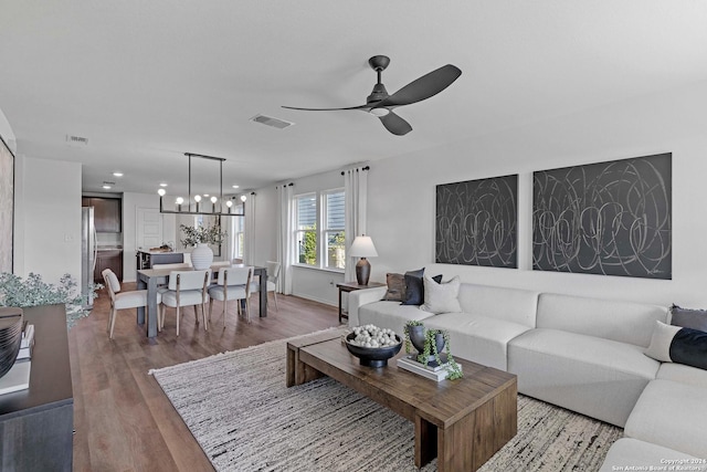 living room with hardwood / wood-style floors and ceiling fan with notable chandelier