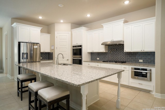 kitchen with white cabinets, sink, an island with sink, and stainless steel appliances