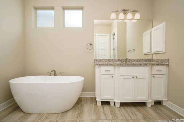 bathroom with hardwood / wood-style floors, vanity, and a bath