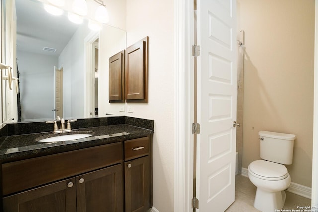 bathroom featuring toilet, vanity, and tile patterned floors