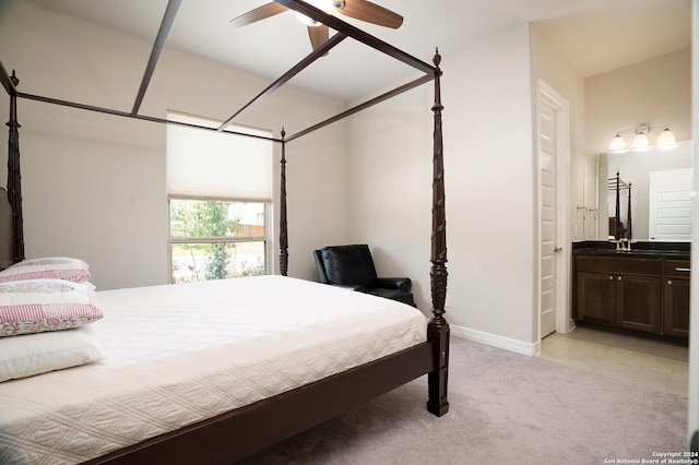 carpeted bedroom with ensuite bathroom and ceiling fan