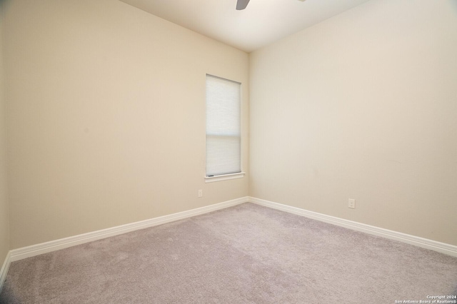 carpeted spare room featuring ceiling fan