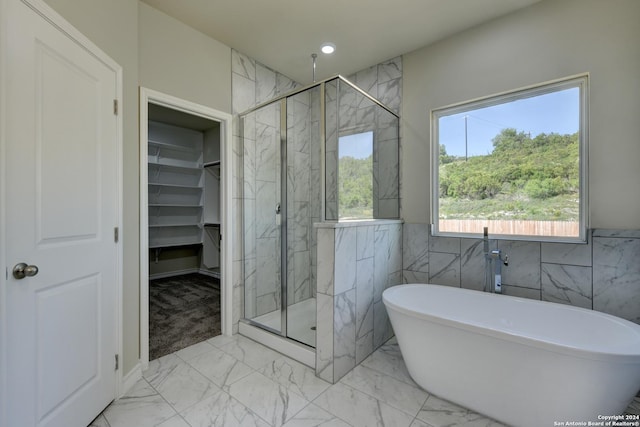 bathroom featuring tile walls and plus walk in shower