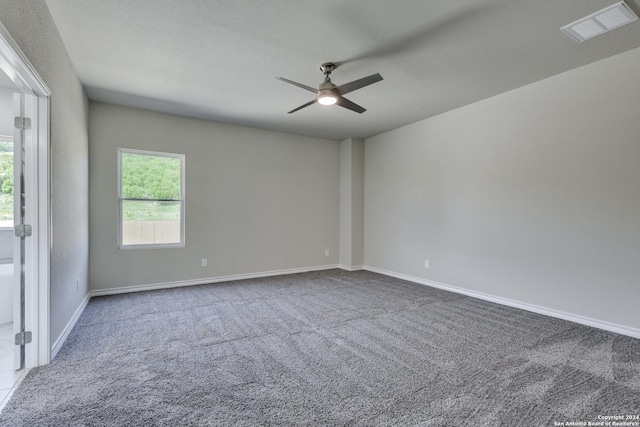 carpeted spare room featuring ceiling fan and a textured ceiling