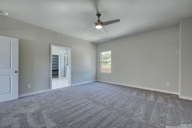 carpeted empty room featuring ceiling fan and a textured ceiling