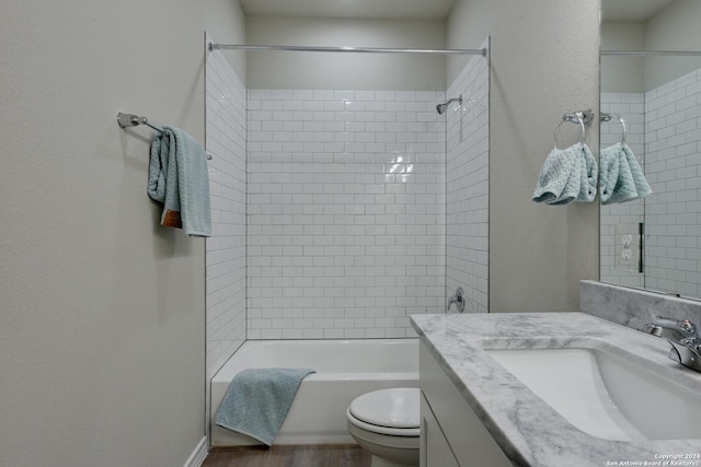 full bathroom featuring hardwood / wood-style flooring, toilet, vanity, and tiled shower / bath