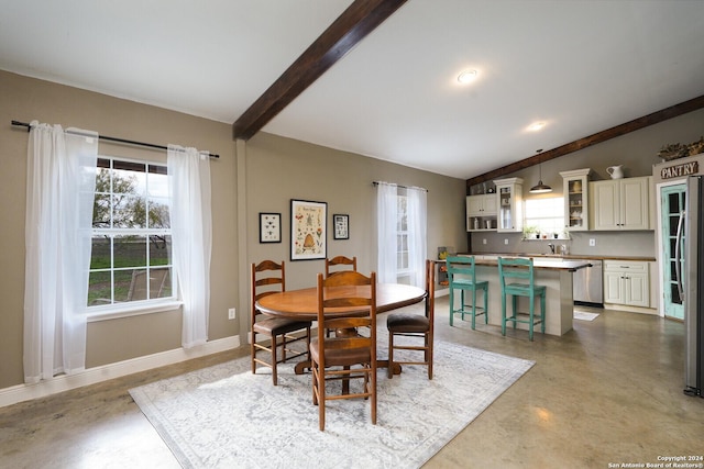 dining area featuring lofted ceiling with beams