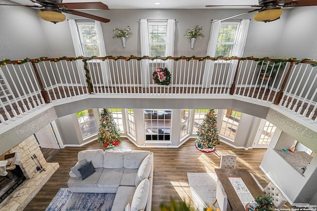 living room with a fireplace, dark hardwood / wood-style flooring, and a towering ceiling