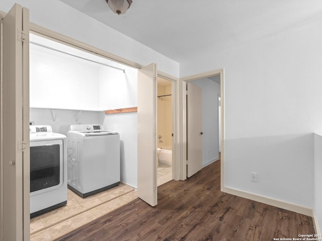 washroom with independent washer and dryer and wood-type flooring