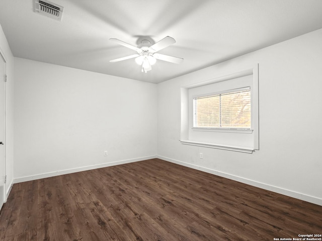 empty room with ceiling fan and dark hardwood / wood-style floors