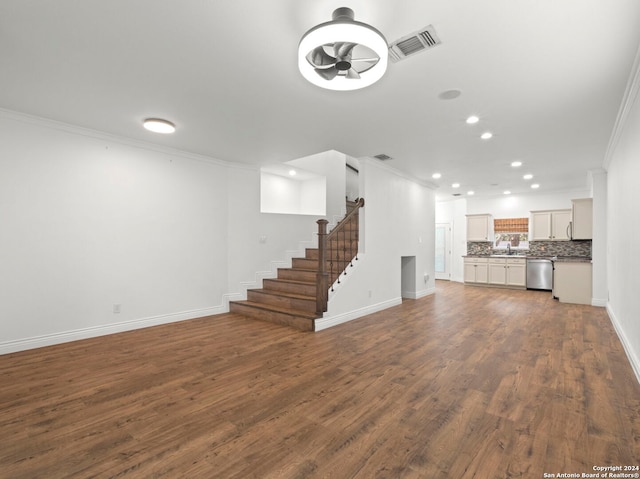 unfurnished living room featuring sink, ornamental molding, and dark wood-type flooring