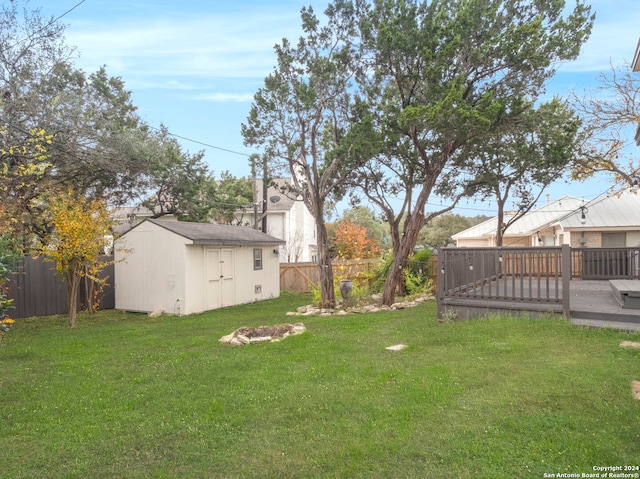 view of yard with a deck and a storage unit