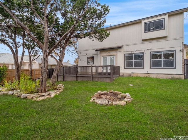 rear view of house with a wooden deck and a yard