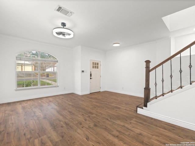 entrance foyer with a skylight, crown molding, and dark hardwood / wood-style floors