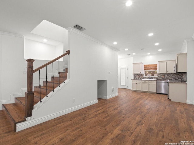 kitchen featuring hardwood / wood-style floors, dishwasher, backsplash, white cabinets, and ornamental molding