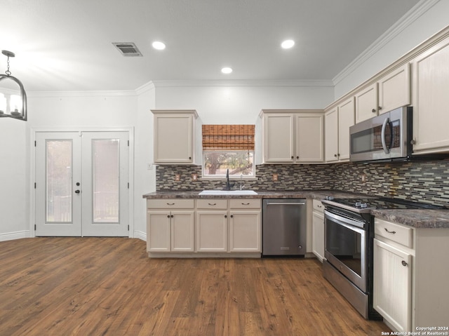 kitchen featuring pendant lighting, sink, stainless steel appliances, and dark wood-type flooring