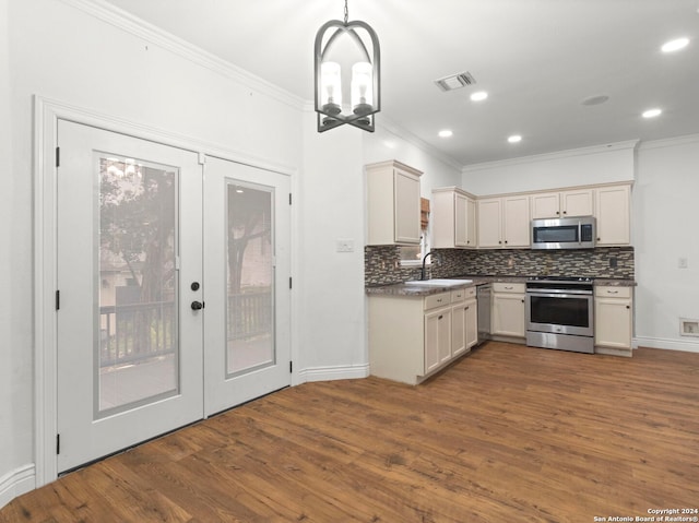 kitchen featuring french doors, sink, hanging light fixtures, appliances with stainless steel finishes, and dark hardwood / wood-style flooring