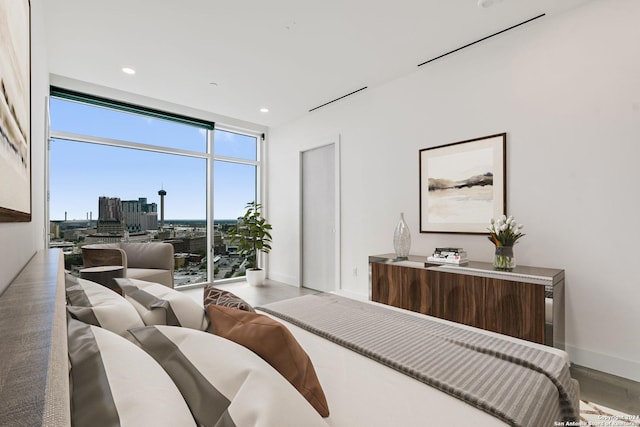 bedroom with expansive windows, hardwood / wood-style flooring, and multiple windows