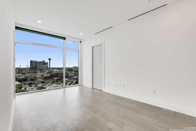 spare room with light wood-type flooring and expansive windows