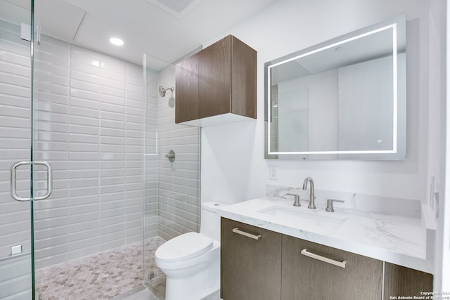 bathroom featuring vanity, an enclosed shower, and toilet