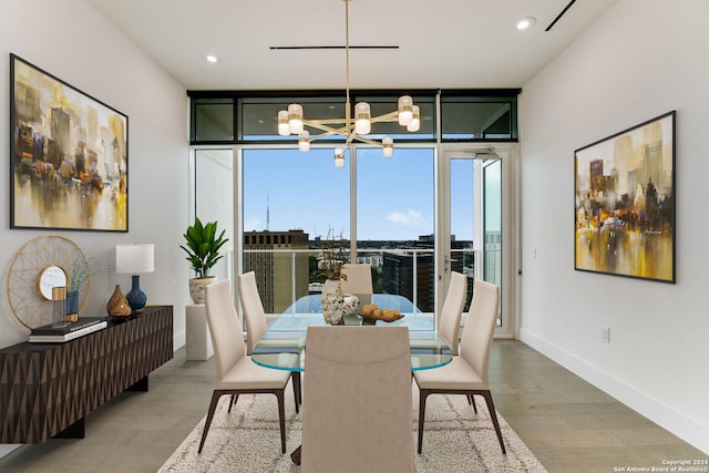 dining area featuring a wall of windows, an inviting chandelier, and light wood-type flooring