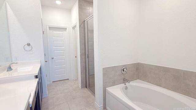 bathroom featuring tile patterned floors, vanity, and shower with separate bathtub