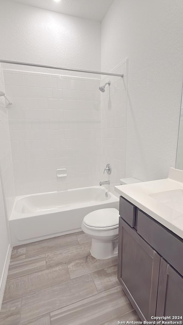 full bathroom featuring vanity, toilet, and tiled shower / bath