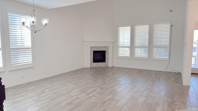 unfurnished living room featuring light hardwood / wood-style flooring and an inviting chandelier