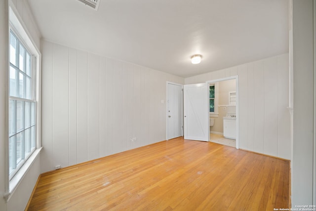 empty room with hardwood / wood-style floors and wood walls