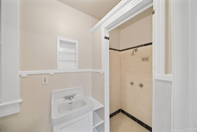 bathroom with tiled shower and sink